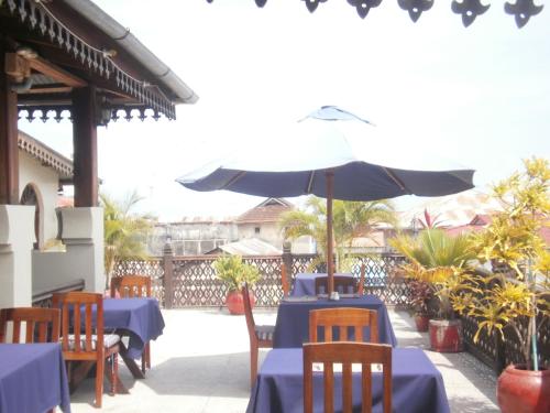 a table with an umbrella on a patio at Asmini Palace Hotel in Zanzibar City