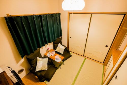 a room with a green curtain and a couch with pillows at Bunkyo-ku Hakusan House in Tokyo