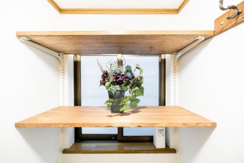a vase of flowers sitting on a table at Bunkyo-ku Hakusan House in Tokyo