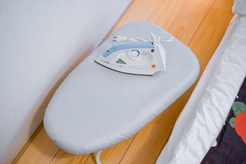 a white iron sitting on top of a bed at Bunkyo-ku Hakusan House in Tokyo