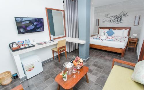 a hotel room with a bed and a table with food on it at Home Chic Hotel in Phnom Penh