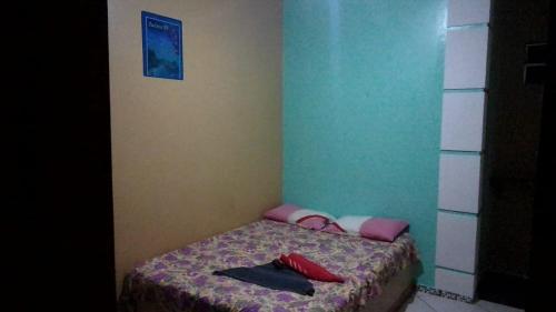 a small bedroom with a bed with a blanket at Pousada Salmo 23 in Algodoal