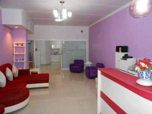 a living room with purple walls and a red couch at MT-Room in Bangkok