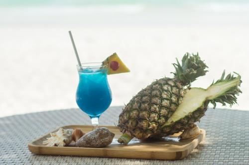 a plate with a pineapple and a drink on a table at Sur Beach Resort Boracay in Boracay