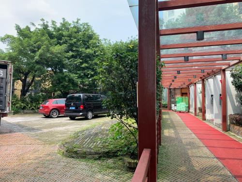 a building with a red walkway next to a parking lot at Guangzhou Fangyuan Hotel - Free Shuttle Bus to Canton Fair Complex during 14th Oct to 3rd Nov in Guangzhou