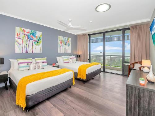 Un dormitorio con dos camas y una gran ventana. en Luxury waterfront sea view apartment - do not book, en Cairns