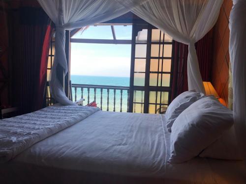 a bedroom with a bed with a view of the ocean at Full Moon Beach Resort in Mui Ne