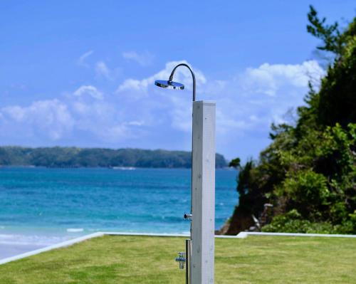 a street light on a pole next to the ocean at Aquaholic Iritahama in Shimoda