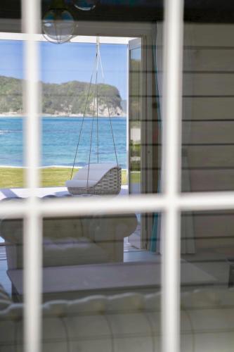 a view of the ocean from a window with a swing at Aquaholic Iritahama in Shimoda