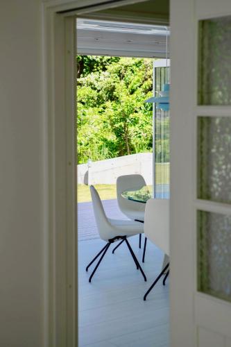 a table and chairs on a porch with a glass door at Aquaholic Iritahama in Shimoda