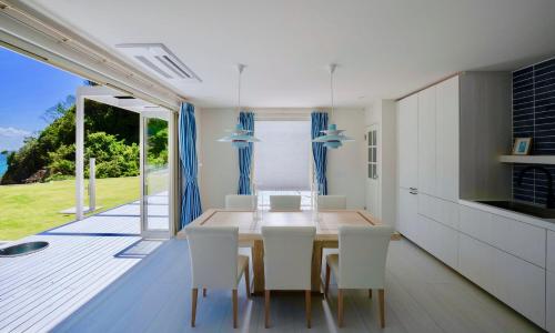 a kitchen and dining room with a table and chairs at Aquaholic Iritahama in Shimoda
