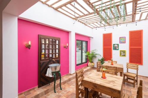 Pokój z różową ścianą i drewnianym stołem w obiekcie Hotel Boutique Santa Lucía w mieście Aquismón