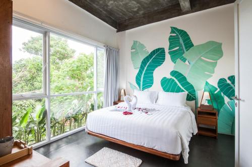 a bedroom with a bed and a large window at Ohana Retreat Bali in Mengwi