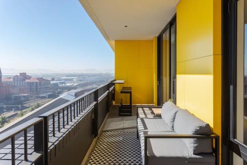 a balcony with couches and a yellow wall at Brand new penthouse with waterfront views in Cape Town