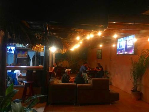 a group of people sitting in a living room at night at Hotel La Choza Inn in Fortuna