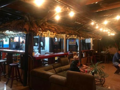 a woman sitting on a couch in a bar at Hotel La Choza Inn in Fortuna