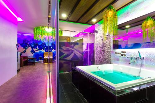 a bathroom with a tub with purple lighting at Sweety Resort in Bangna