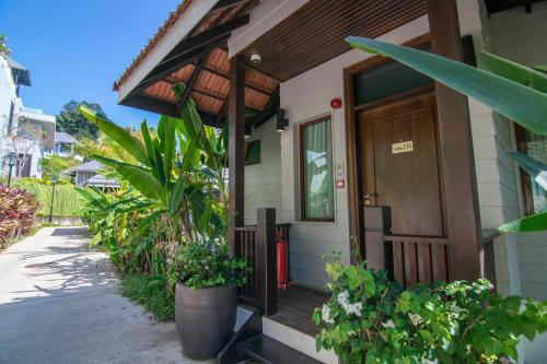 a house with a wooden door and some plants at Royale Chulan Cherating Villa in Cherating