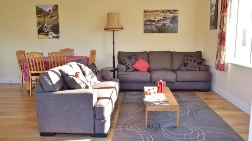 a living room with a couch and a table at Golden Hills Farm Cottage in Nelson
