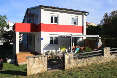 a house with a stone fence in front of it at Holiday Home Radmila in Premantura