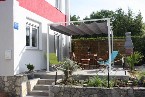 a patio with a table and chairs under a pergola at Holiday Home Radmila in Premantura