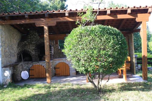 a wooden pergola with a tree in a yard at Holiday Home Radmila in Premantura