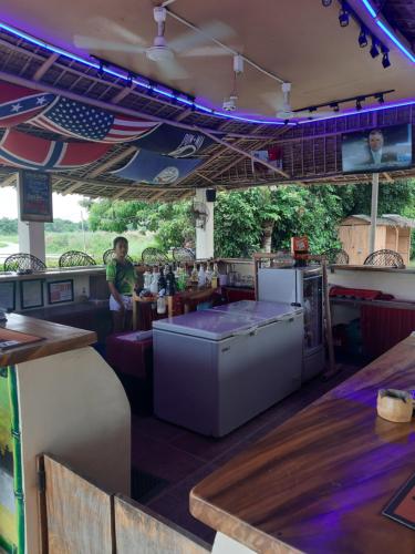 an empty restaurant with a man sitting at a bar at Monty's Riverside View Resort in San Antonio