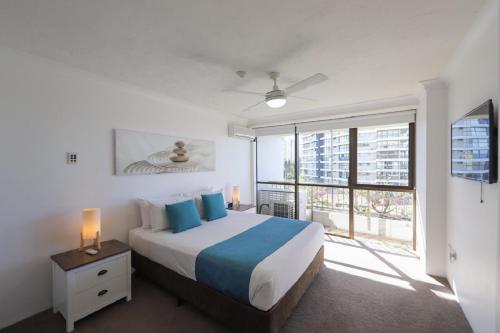 a bedroom with a bed and a large window at Bougainvillea Gold Coast Holiday Apartments in Gold Coast