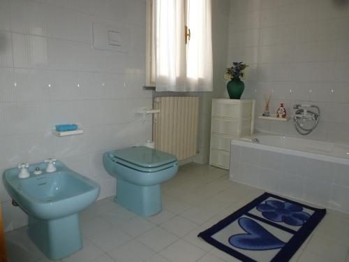 een badkamer met een blauw toilet en een bad bij La Martlona in Riccione