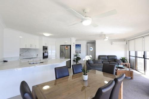 a kitchen and living room with a table and chairs at Bougainvillea Gold Coast Holiday Apartments in Gold Coast