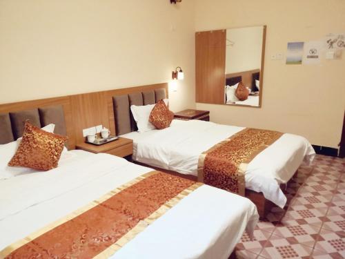 a hotel room with two beds and a mirror at Holly's Hostel in Chengdu