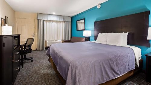um quarto de hotel com uma cama grande e uma secretária em Best Western Apricot Inn em Chaney Ranch