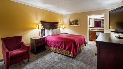 a hotel room with a bed and a chair at Osage Creek Lodge in Eureka Springs