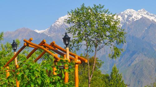 a group of orange pipes with mountains in the background at Himalayan High, Auli, By Himalayan Eco Lodges in Joshīmath