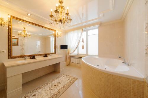 a bathroom with a tub and a large mirror at Hotel Barnaul in Barnaul