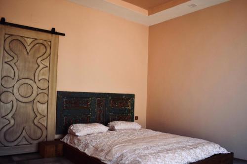 a bedroom with a bed with a wooden headboard at HemDem Alçıtepe in Canakkale