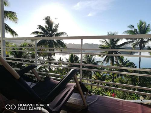 a chair on a balcony with a view of the ocean at Suva Hideaway Villa in Suva