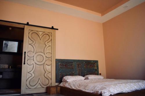 a bedroom with a bed with a wooden door at HemDem Alçıtepe in Canakkale