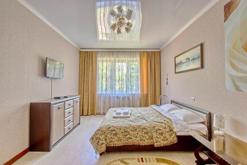 a bedroom with a bed and a dresser and a window at Cozy apartment on Rozybakiev 145. Atakent in Almaty
