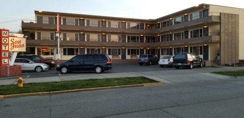 a large building with cars parked in a parking lot at San Juan Motel in Anacortes