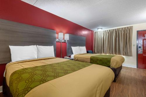 2 Betten in einem Hotelzimmer mit roten Wänden in der Unterkunft Econo Lodge in Chattanooga