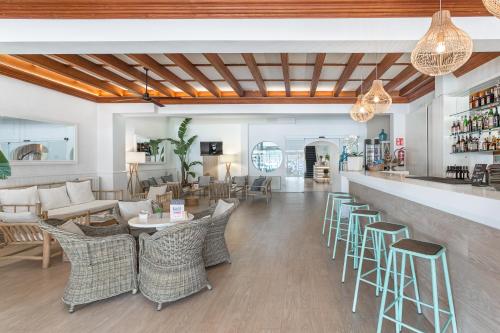 a restaurant with tables and chairs and a bar at FERGUS Style Soller Beach in Port de Soller