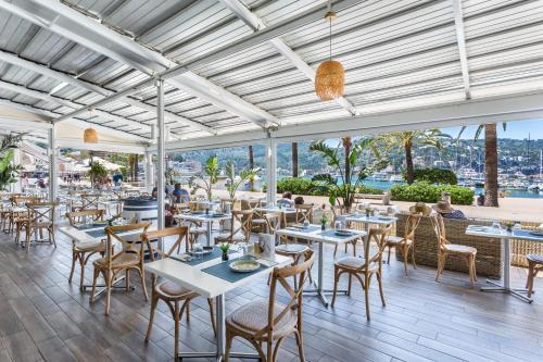 a restaurant with tables and chairs and a view of the water at FERGUS Style Soller Beach in Port de Soller
