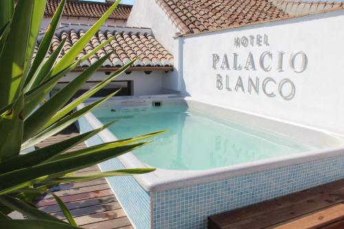uma piscina com uma placa que lê Hotel Palapa blancaambo em Hotel Palacio Blanco em Vélez-Málaga