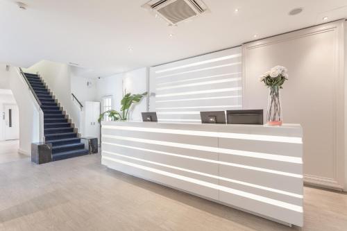 a lobby with a reception desk and a staircase at FERGUS Style Soller Beach in Port de Soller