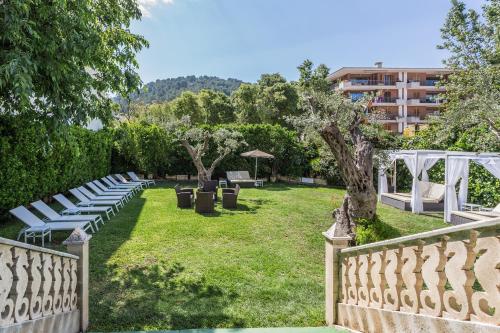 a row of white lounge chairs in a park at FERGUS Style Soller Beach in Port de Soller