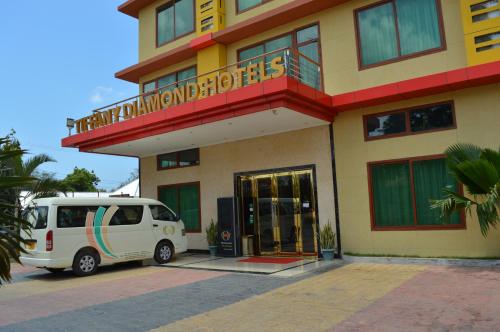 a white van parked in front of a building at Tiffany Diamond Hotels - Mtwara in Mtwara