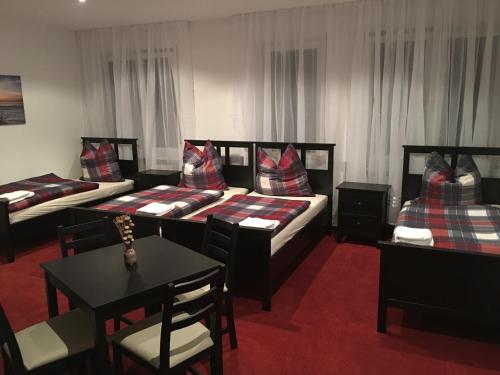 a hotel room with two beds and a table and chairs at Jimmy Gastronomie & Übernachtung in Altheim