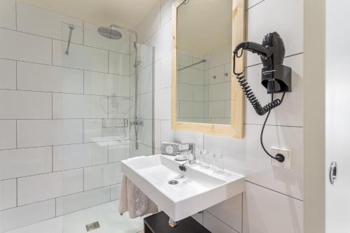 a white bathroom with a sink and a phone at FERGUS Style Soller Beach in Port de Soller