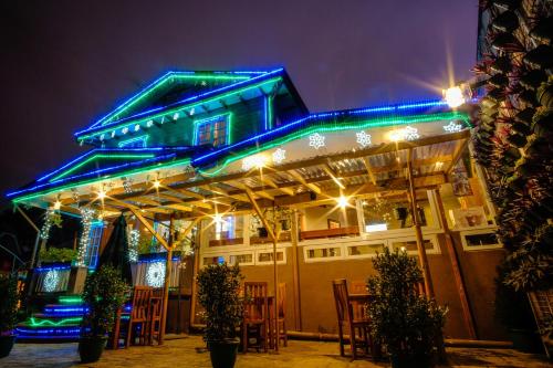 a restaurant with blue lights on the roof at night at Elmar Cabin in Baguio